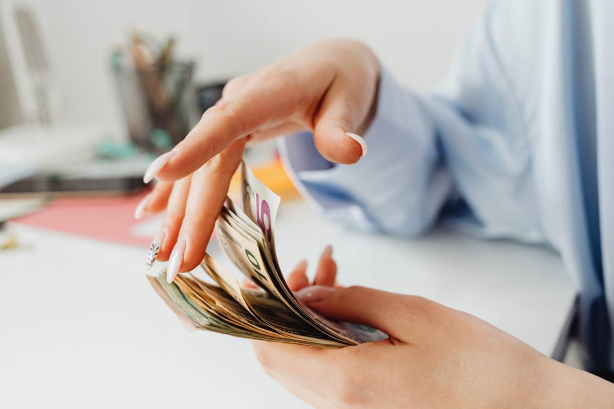 Donna che sfoglia banconote euro