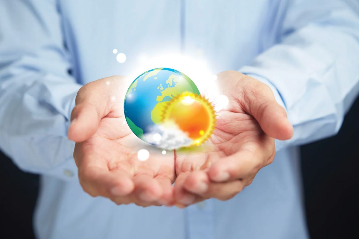 Uomo con immagine in miniatura di un sole e della terra tra le mani
