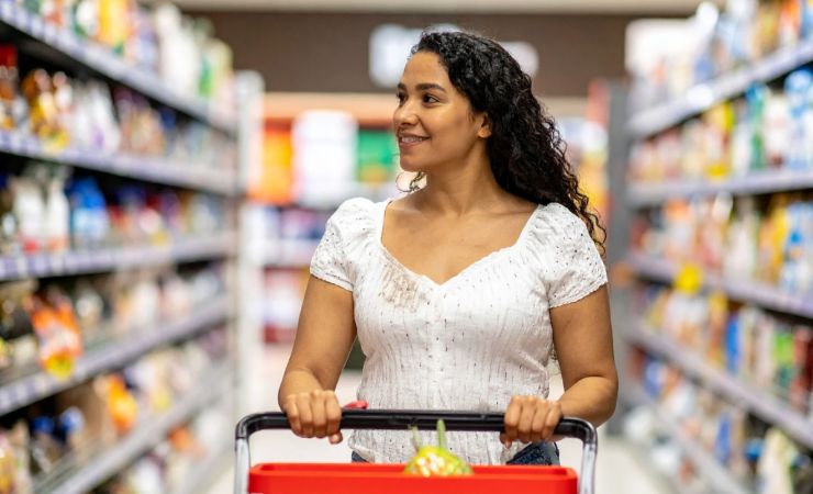 Donna al supermercato che spinge carrello