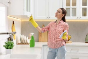 Donna che pulisce la cucina con il sorriso