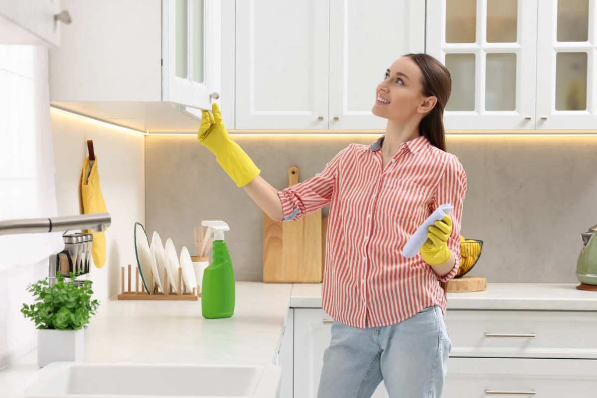 Donna che pulisce la cucina con il sorriso