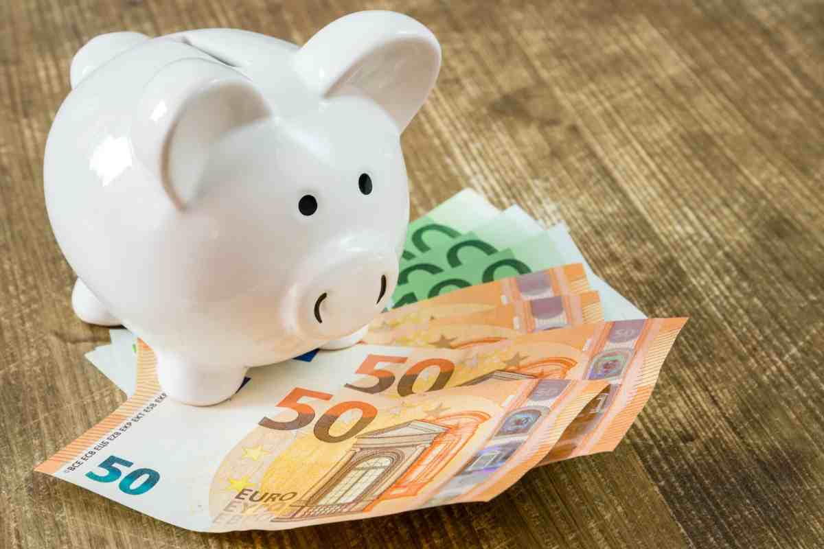 Banconote euro con salvadanaio bianco a forma di maialino