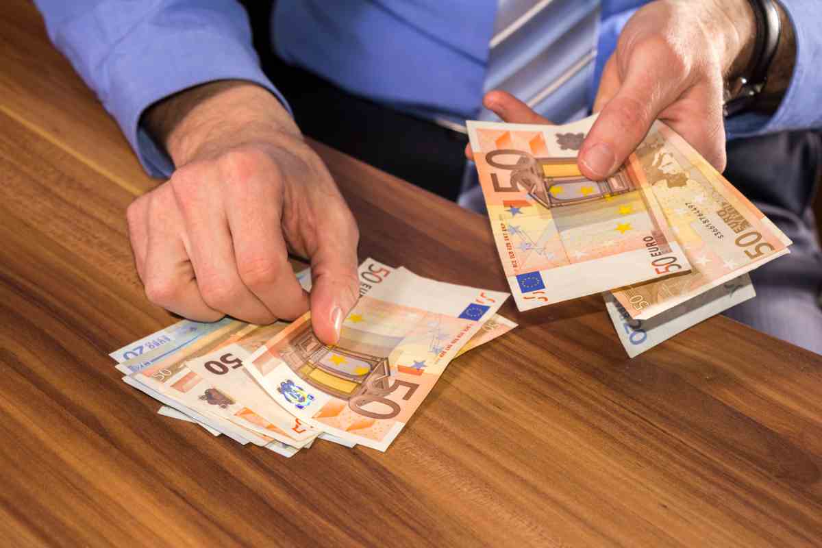 Uomo che conta banconote euro