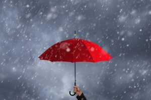 Ombrello rosso sotto la pioggia tenuto da una mano