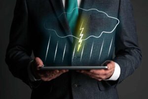 Uomo con tablet in mano e nuvola con pioggia e fulmini