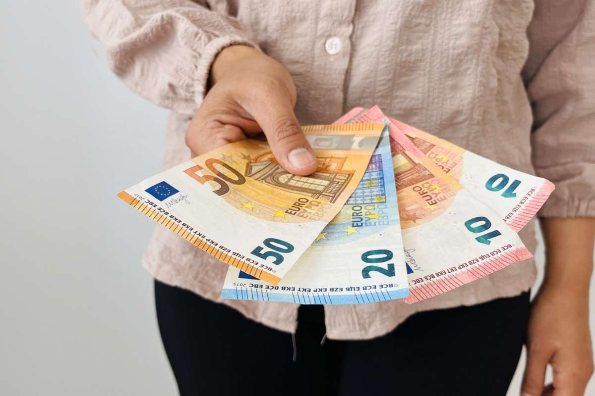 Persona che tiene in mano banconote euro