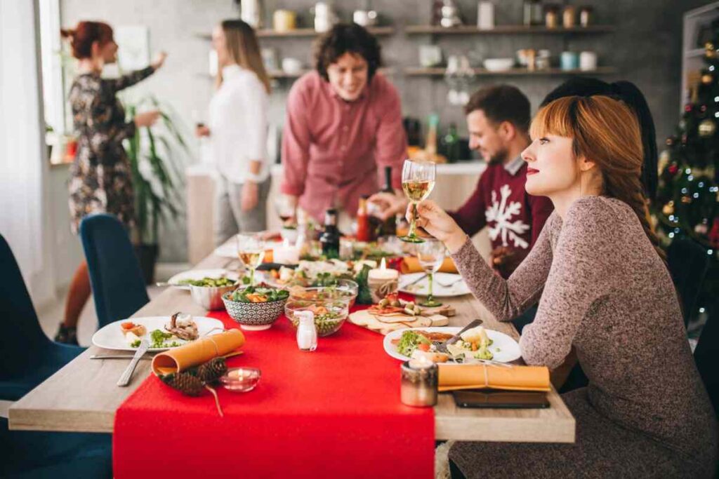 Persone sedute per pranzo di Natale, con tavola imbandita
