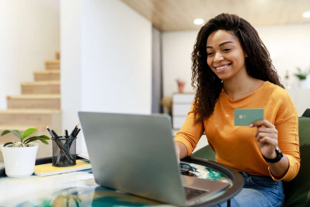 Donna con carta di credito di fronte al pc
