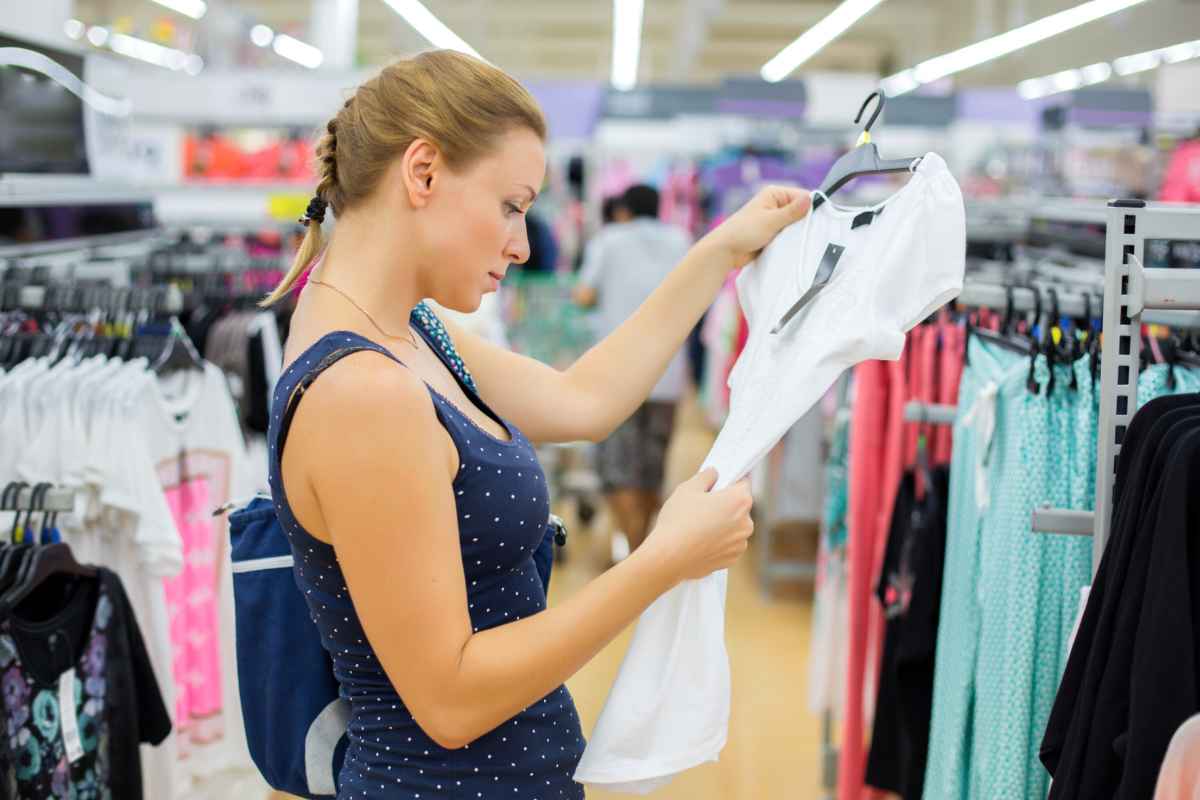Donna in un negozio che osserva maglietta